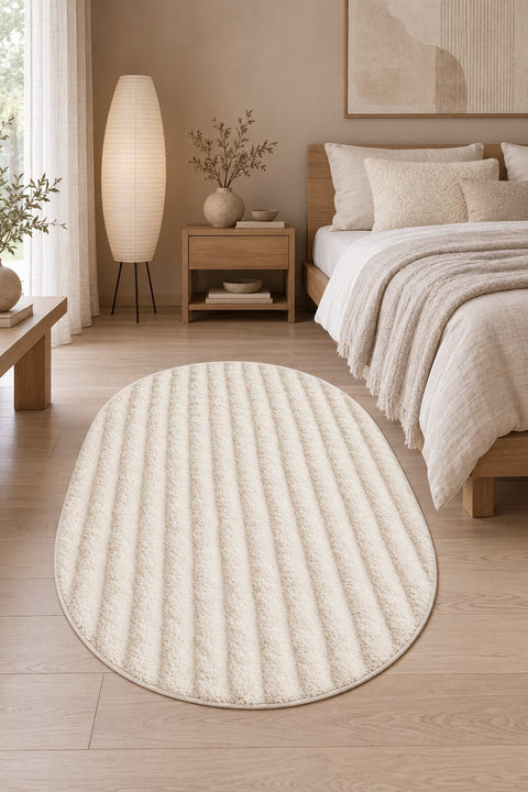 Solid Modern Oval Shag Rug – Cream in a bedroom