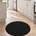 Solid Modern Round Plush Rug – Black in a kitchen