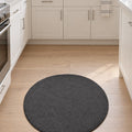 Solid Modern Round Plush Rug – Charcoal in a kitchen