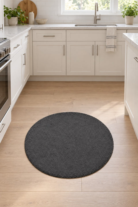 Solid Modern Round Plush Rug – Charcoal in a kitchen