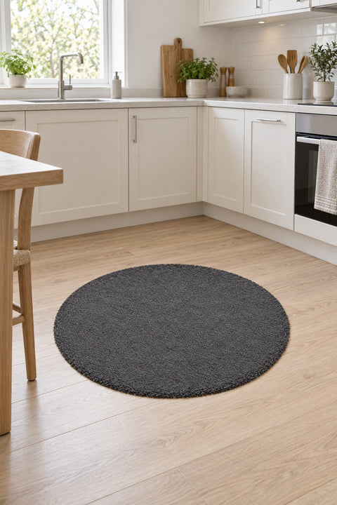 Solid Modern Round Plush Rug – Charcoal in a kitchen