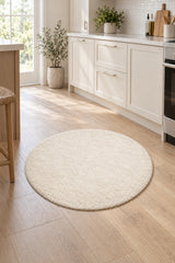 Solid Modern Round Plush Rug – Ecru in a kitchen