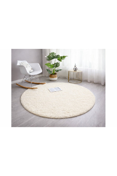 Solid Modern Round Plush Rug – Ecru in a living room