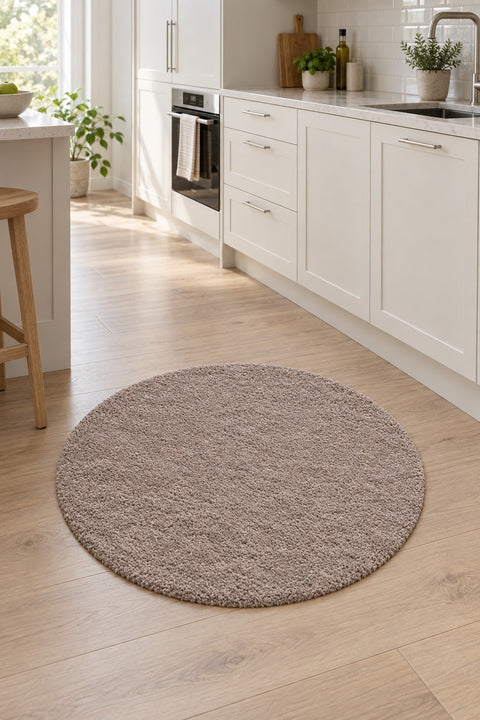 Solid Modern Round Plush Rug – Taupe in a kitchen